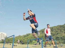 Carlos Fierro salta una serie de tubos durante el entrenamiento de Chivas en Colima. ESPECIAL  /