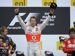 Jenson Button (c) celebra su victoria en el Gran Premio de Hungría, junto a Sebastian Vettel (i) y Fernando Alonso. AP  /