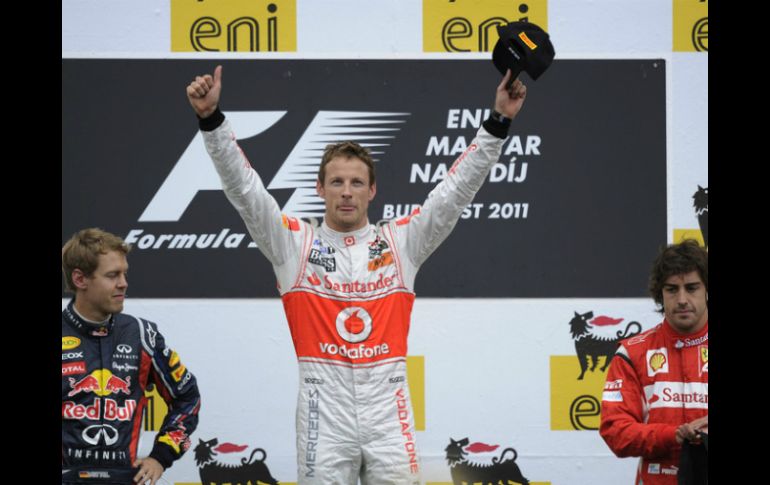 Jenson Button (c) celebra su victoria en el Gran Premio de Hungría, junto a Sebastian Vettel (i) y Fernando Alonso. AP  /