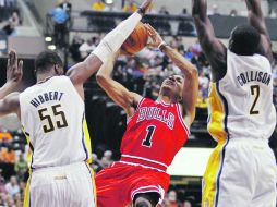 El guardia de Chicago Derrick Rose (centro) dispara a la canasta, ante la marca de Roy Hibbert (izq.) y Darren Collison, de Indiana. AP  /