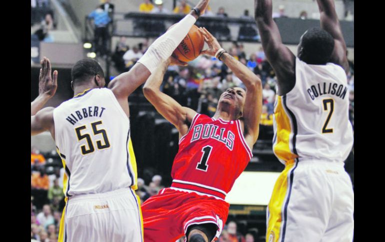 El guardia de Chicago Derrick Rose (centro) dispara a la canasta, ante la marca de Roy Hibbert (izq.) y Darren Collison, de Indiana. AP  /