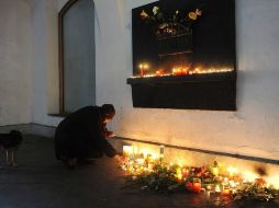 Una mujer enciendeuna vela en recuerdo a Havel en el monumento a los estudiantes en la calle calle Narodni. EFE  /