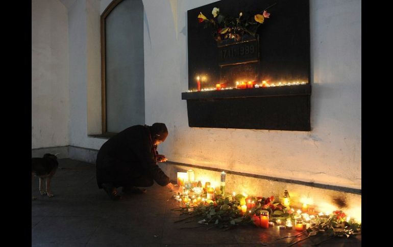 Una mujer enciendeuna vela en recuerdo a Havel en el monumento a los estudiantes en la calle calle Narodni. EFE  /