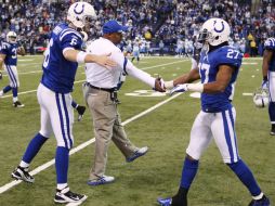 Jim Caldwell, entrenador de Indianapolis  y el mariscal de campo Dan Orlovsky Colts (6) saludan a los defensa Jacob Lacey (27). REUTERS  /