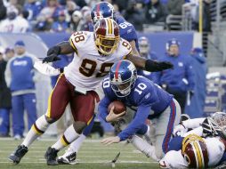 Brian Orakpo (I) salta sobre Eli Manning (C) después de que su compañero Stephen Bowen le capturara, (Abajo- Der). AP  /