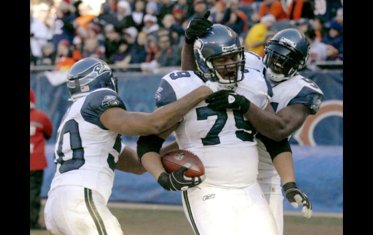 Red Bryant (79) celebra con sus compañeros después de anotar en un regreso de intercepción del partido contra los Osos de Chicago. AP  /