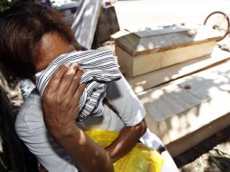 Una mujer llora junto a un ataúd en la localidad filipina de Cayagan de Oro, tras el paso de la devastadora tormenta tropical. EFE  /