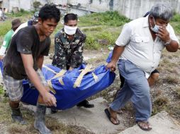 Soldados filipinos transportan el cuerpo de una persona que murió en una aldea devastada por la tormenta tropical 'Washi'. EFE  /