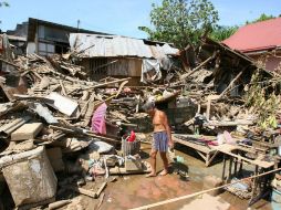 Damnificados filipinos buscan materiales reutilizables en las ruinas de una casa dañada por las inundaciones. NTX  /