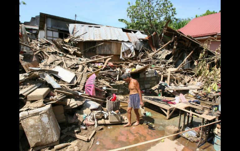 Damnificados filipinos buscan materiales reutilizables en las ruinas de una casa dañada por las inundaciones. NTX  /