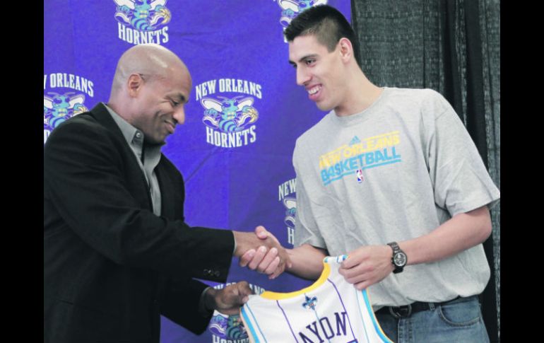 El gerente general de los Hornets de Nueva Orleáns, Dell Demps, le da la bienvenida a Gustavo Ayón. AP  /