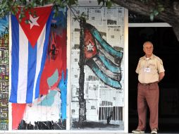 Un vigilante permanece junto a la entrada de un edificio adornada con banderas de Cuba hoy, sábado 24 de diciembre de 2011. EFE  /