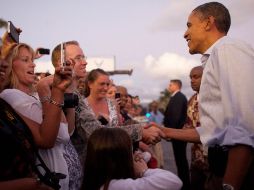 Obama saluda a la multitud a su llegada a la Base Conjunta Harbor-Hickam en Honolulu. EFE  /