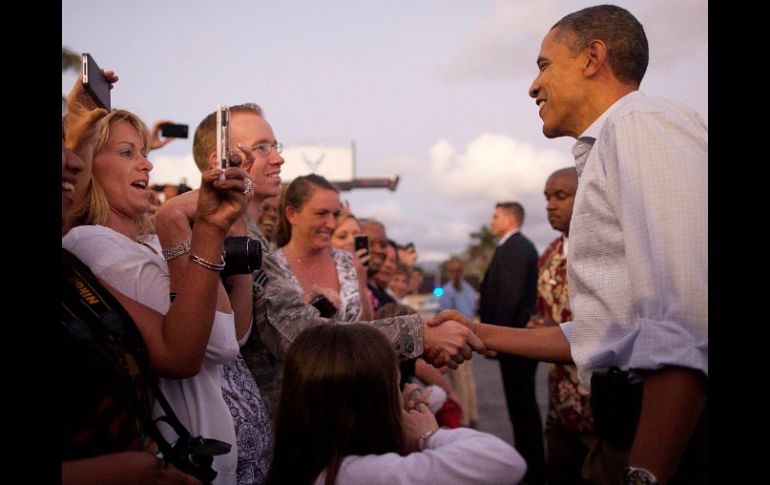 Obama saluda a la multitud a su llegada a la Base Conjunta Harbor-Hickam en Honolulu. EFE  /