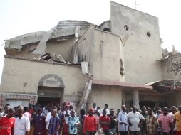 Pobladores acuden al sitio de la explosión que destruyó parte de la iglesia de Santa Teresa en Abuja. AFP  /