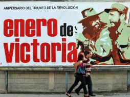 Una pareja camina junto a un cartel alusivo al aniversario de la revolución cubana, en La Habana. EFE  /