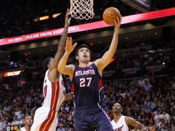 Zaza Pachulia encesta entre los defensas de Miami Udonis Haslem (i) y Chris Bosh (d). REUTERS  /