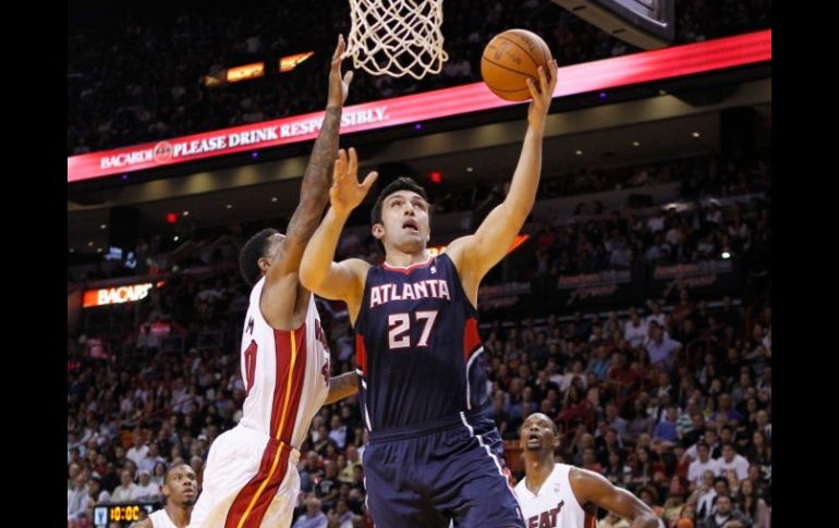 Zaza Pachulia encesta entre los defensas de Miami Udonis Haslem (i) y Chris Bosh (d). REUTERS  /