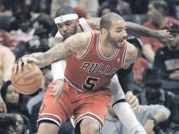 Josh Smith (de blanco), de los Hawks de Atlanta, intenta robarle el balón a Carlos Boozer, de los Bulls de Chicago. AP  /