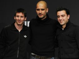 Lionel Messi (i), el entrenador del Barcelona, Josep Guardiola (c), y el centrocampista español Xavi Hernández (d). AP  /