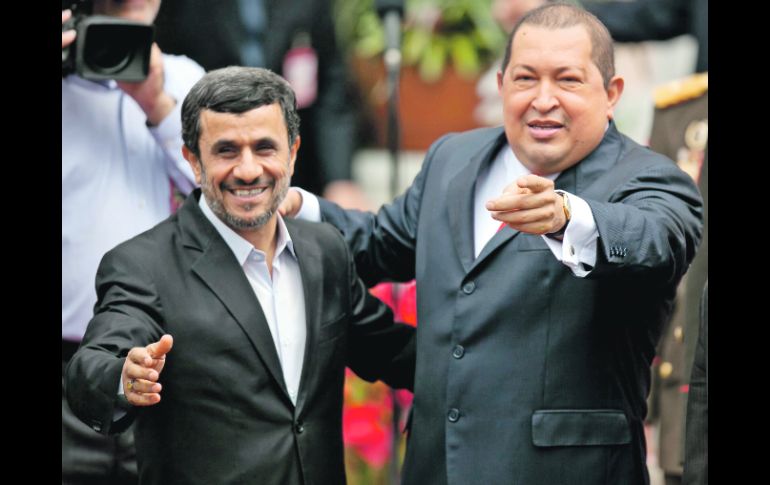 El presidente venezolano, Hugo Chávez (d), saluda a la prensa acompañado de su homólogo iraní, Mahmoud Ahmadinejad. EFE  /