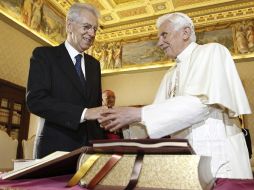 El papa Benedicto XVI (d) estrecha la mano del primer ministro italiano, Mario Monti (i). EFE  /