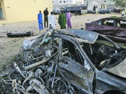 Personas observan coches destruidos en el sitio de un bombardeo suicida en la sede de Policía en Kano, Nigeria. AP  /