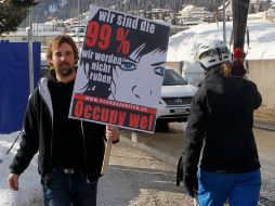 Miembro del movimiento ''Occupy WEF'' sostiene un cartel que dice: somos un 99%, que solía descansar. AP  /