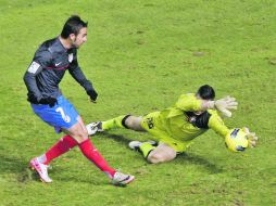 El guardameta de Osasuna, Andrés Fernández (derecha), detiene el disparo del delantero del Atlético de Madrid, Adrián López. EFE  /