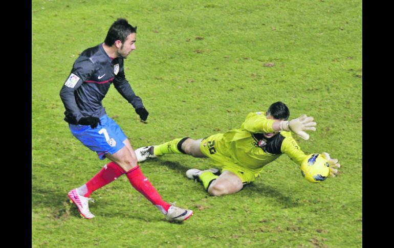 El guardameta de Osasuna, Andrés Fernández (derecha), detiene el disparo del delantero del Atlético de Madrid, Adrián López. EFE  /