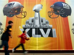 Indianápolis es la actual sede del XLVI Super Bowl. En la imagen, unos fanáticos pasan frente a un letrero en dicha ciudad. EFE  /