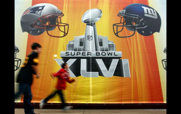 Indianápolis es la actual sede del XLVI Super Bowl. En la imagen, unos fanáticos pasan frente a un letrero en dicha ciudad. EFE  /