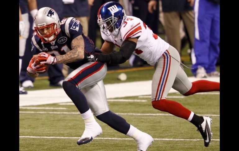 Aaron Hernández de los Patriotas se aleja de Dean Grant de los Gigantes durante el primer tiempo del Super Bowl XLVI. REUTEURS  /