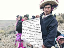 Felipe Bautista muestra un cartel donde señala la importancia que tiene preservar para los huicholes la tierra de sus antepasados.  /