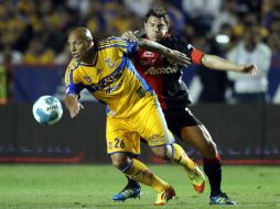 El delantero de Tigres, Cunha, trata de quitarse la marca de Erpen de los Zorros durante el partido. MEXSPORT  /