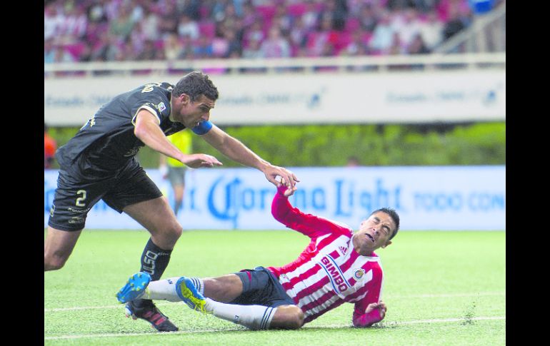 El defensa de San Luis, Aníbal Matellán, le comete falta al volante de Chivas, Marco Fabián.  /