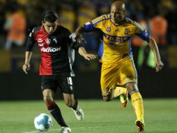 El jugador Arturo Paganoni, del Atlas, disputa el balón con Roberto Cunha, del Tigres. AFP  /