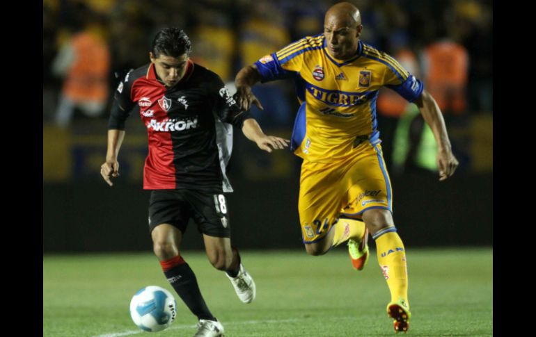 El jugador Arturo Paganoni, del Atlas, disputa el balón con Roberto Cunha, del Tigres. AFP  /