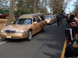 Seguidores de la cantante arrojan flores a la carroza que transporta sus restos al cementerio. AFP  /