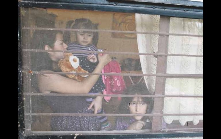 Acompañada por una sobrina, Nayeli Hernández carga a su hija Leonor, a la que intentó inscribir en primero de preescolar.  /