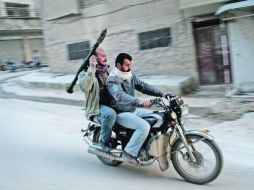 Seguidores del Ejército Sirio Libre vigilan las calles en el Distrito de Taharym, en Siria. AP  /