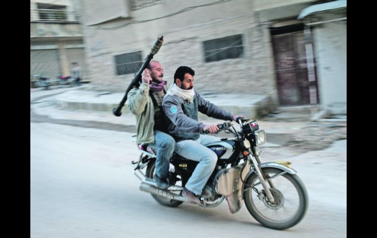 Seguidores del Ejército Sirio Libre vigilan las calles en el Distrito de Taharym, en Siria. AP  /