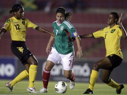 Nayeli Rangel pasa con el balón controlado ante dos jugadoras de Jamaica. AP  /