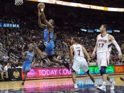 El jugador de los Hawks de Atlanta, Josh Smith, clava la pelota ante la marca de Serge Ibaka, del Thunder de Oklahoma. EFE  /