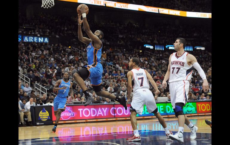 El jugador de los Hawks de Atlanta, Josh Smith, clava la pelota ante la marca de Serge Ibaka, del Thunder de Oklahoma. EFE  /