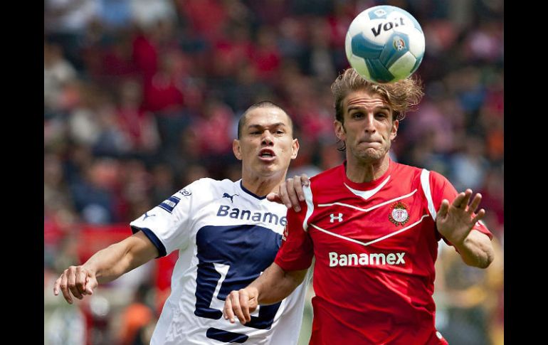 Ivan Alonso (D), delToluca, arrebata el balòn de un movimiento a Dario Veron (I) de Pumas. AFP  /