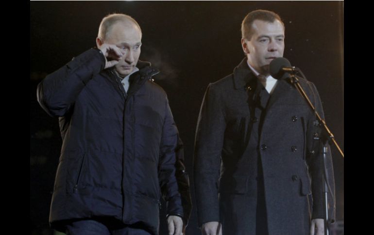 Vladimir Putin (izq) junto al presidente Medvedev (der) tras conocerse los resultados de las elecciones. AP  /