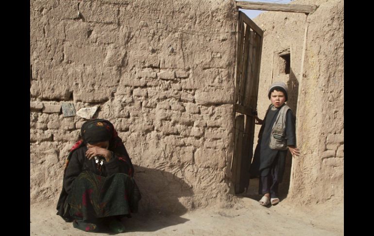 Una mujer afgana descansa junto a su casa de Herat, en otras zonas del país donde neva, los aludes son frecuentes. EFE  /