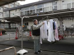 Un daminificado cualga su ropa a secar en un refugio de Fukushima. AP  /