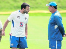 El técnico Enrique “Ojitos” Meza (derecha) platica con su delantero Emanuel Villa, durante el entrenamiento en La Noria. MEXSPORT  /